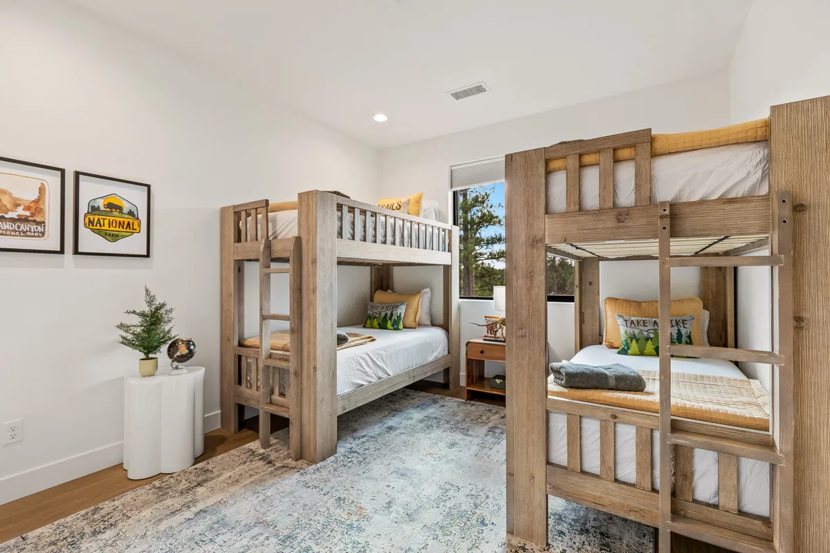 A cheerful kids' room with fun bunk beds, colorful pillows, and playful wall art, designed with younger guests in mind. The cozy space invites play, reading, and a sense of personal retreat for children.